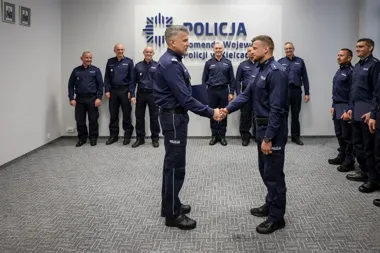 Policjanci w granatowych mundurach uczestniczą w uroczystym wręczeniu dokumentów w siedzibie Komendy Wojewódzkiej Policji w Kielcach.