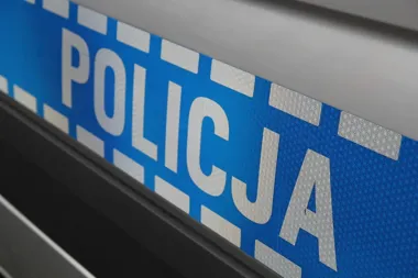 Fragment oznakowania policyjnego na pojeździe z napisem POLICJA.