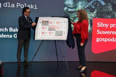 Dwie osoby odsłaniają na scenie planszę z motywami znaczków pocztowych z napisem „Local Content. Z korzyścią dla Polski”, w tle ekran z hasłami i żołnierzem.