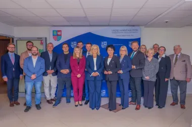 Grupa osób pozuje do pamiątkowego zdjęcia w siedzibie Urzędu Marszałkowskiego Województwa Świętokrzyskiego.